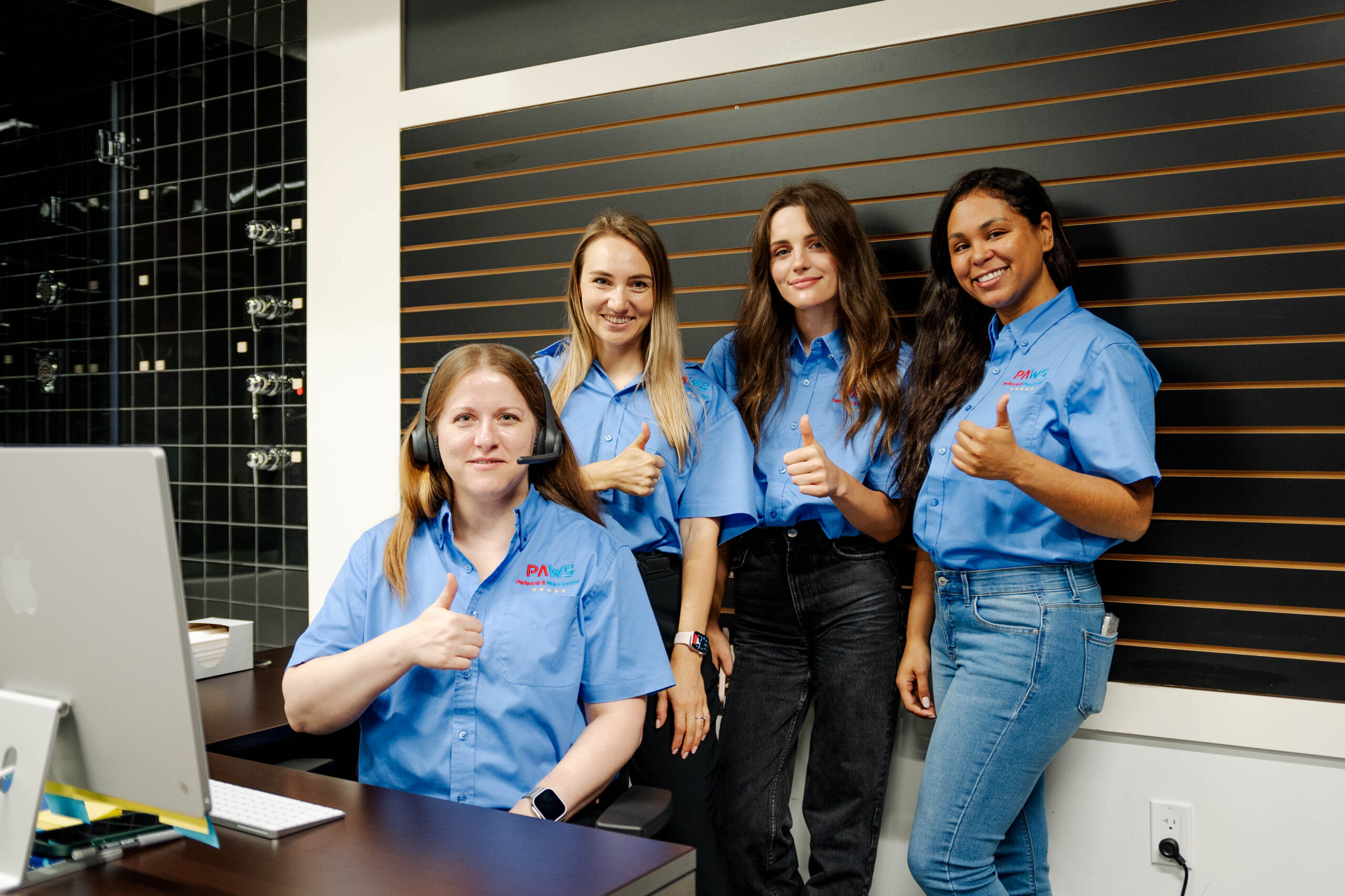 Smiling PAW workers at a desk with a computer